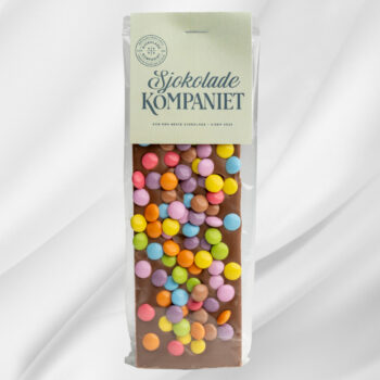 Sjokoladeplate «Barnas Favoritt» – melk- og karamellsjokolade toppet med fargerike sjokoladelinser på hvit bakgrunn