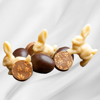 Bilde av en pose med utvalgte påskeprodukter fra Sjokoladekompaniet, fylt med sjokoladetrekte marsipanegg, sjokoladebiter og små marsipanfigurer, pakket i en gavepose til påske.