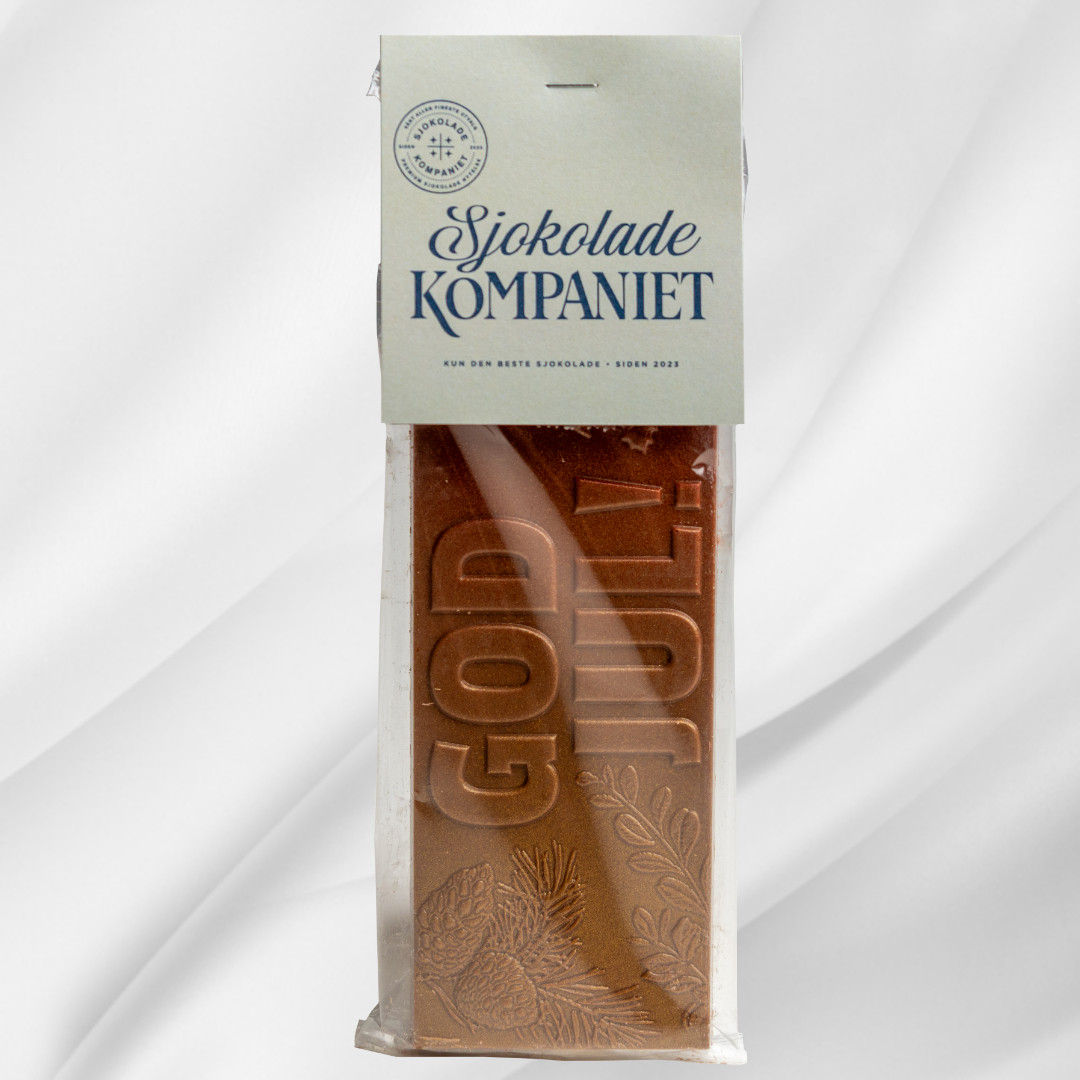 Sjokoladeplate med teksten God Jul i melk- og karamellsjokolade på hvit bakgrunn