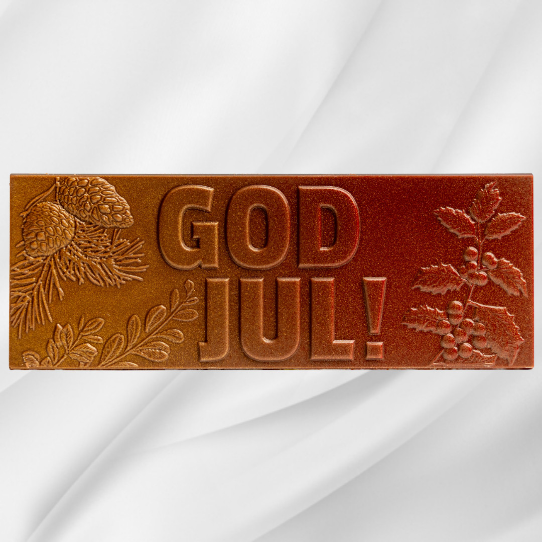 Sjokoladeplate med teksten God Jul i melk- og karamellsjokolade på hvit bakgrunn