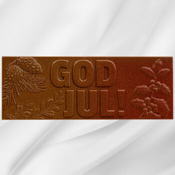 Sjokoladeplate med teksten God Jul i melk- og karamellsjokolade på hvit bakgrunn